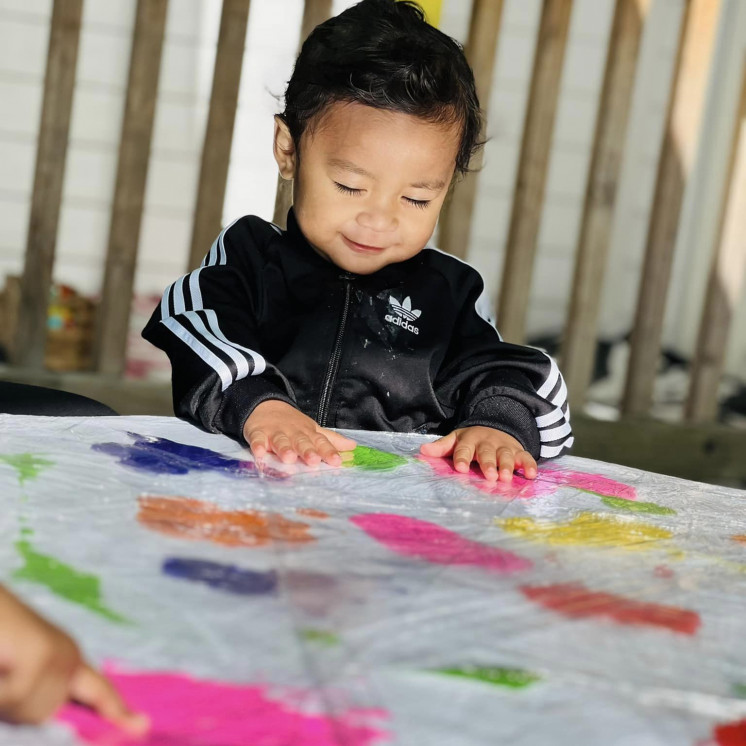 Busy Bees Alfriston Road sensory play with paint in the nursery room