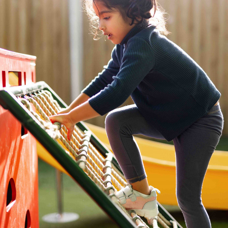  Little girl climbing at the playground of early childhood centre in Palmerston North at Busy Bees on Church Street.
