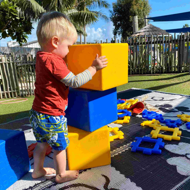 Busy Bees Coopers Beach boy outside stacking blocks