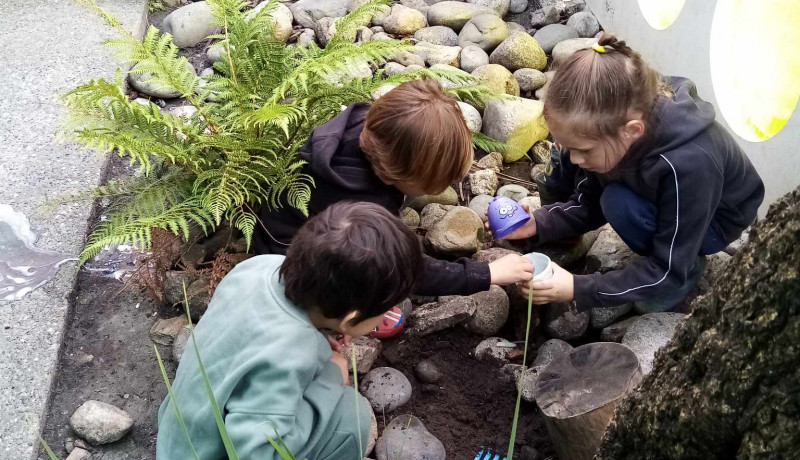 Three friends exploring outdoors for garden treasures at Busy Bees Kawatiri