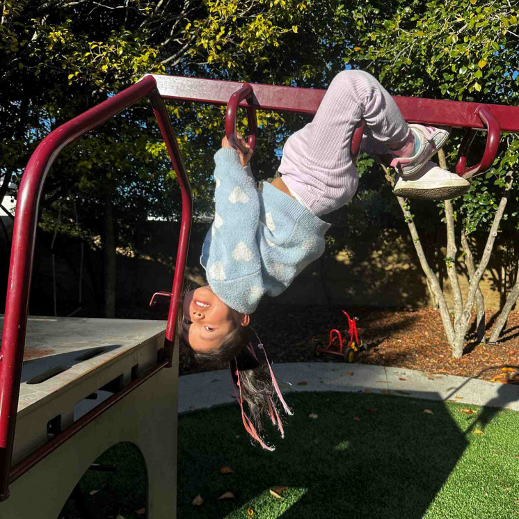 Busy Bees Motueka preschooler challenging herself on the jungle gym
