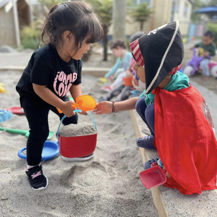 Friends helping each other in the sand pit at Busy Bees Mount Wellington