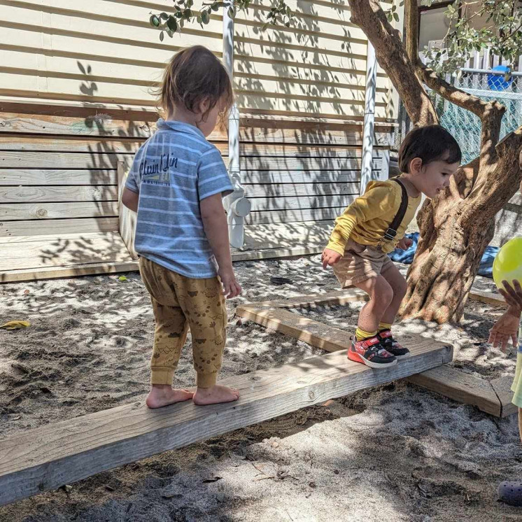 Group of friends playing in the shade at Busy Bees Ōtāhuhu
