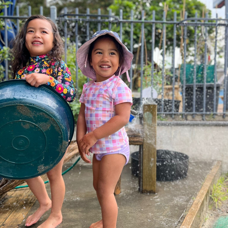 Busy Bees Pakuranga girls playing outside with water 