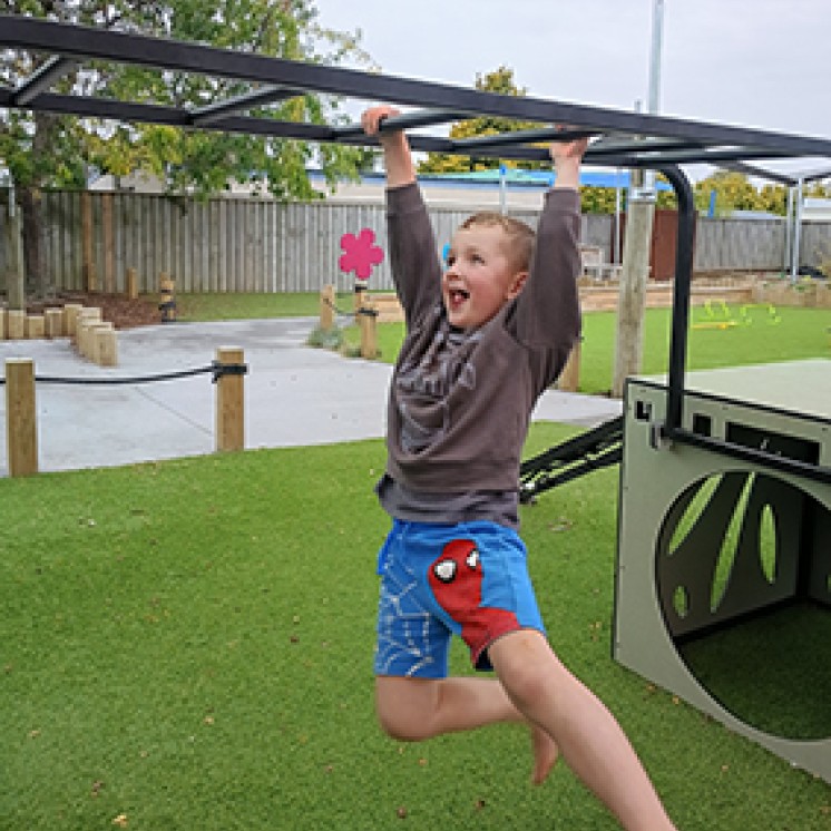 Happy child outdoor challenge monkey bars fun