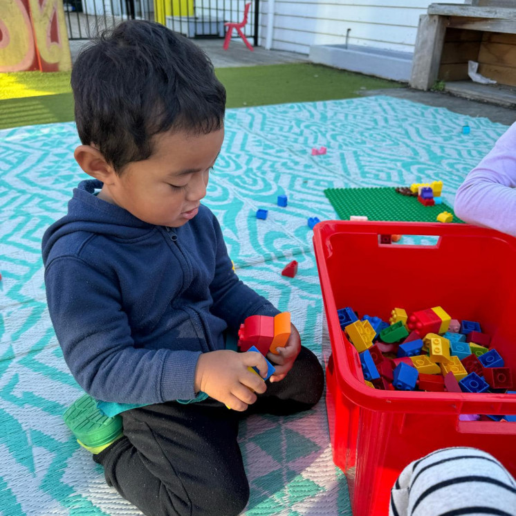 Toddler engaged in creating with colourful lego at Busy Bees Roscommon Road