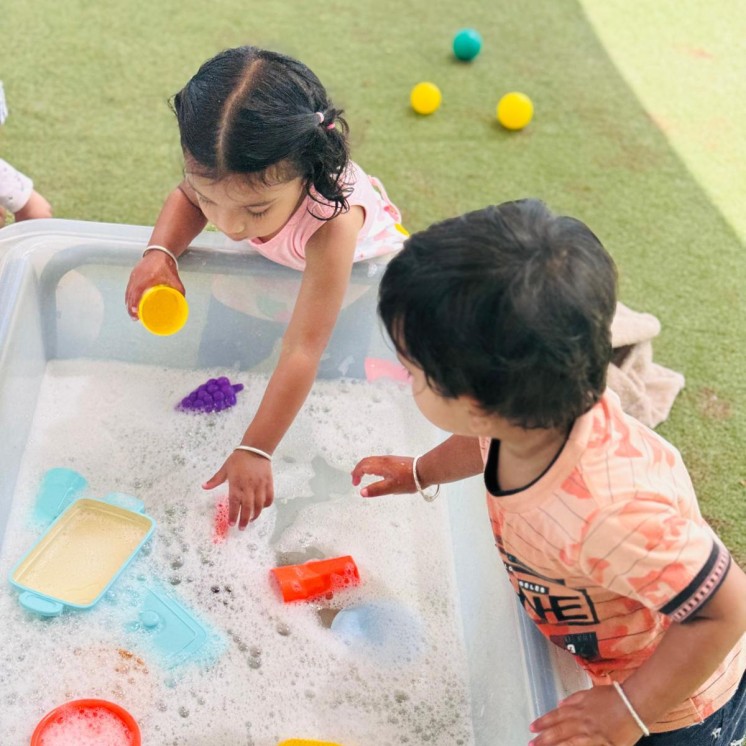Busy Bees Te Rapa kids playing outside with water 