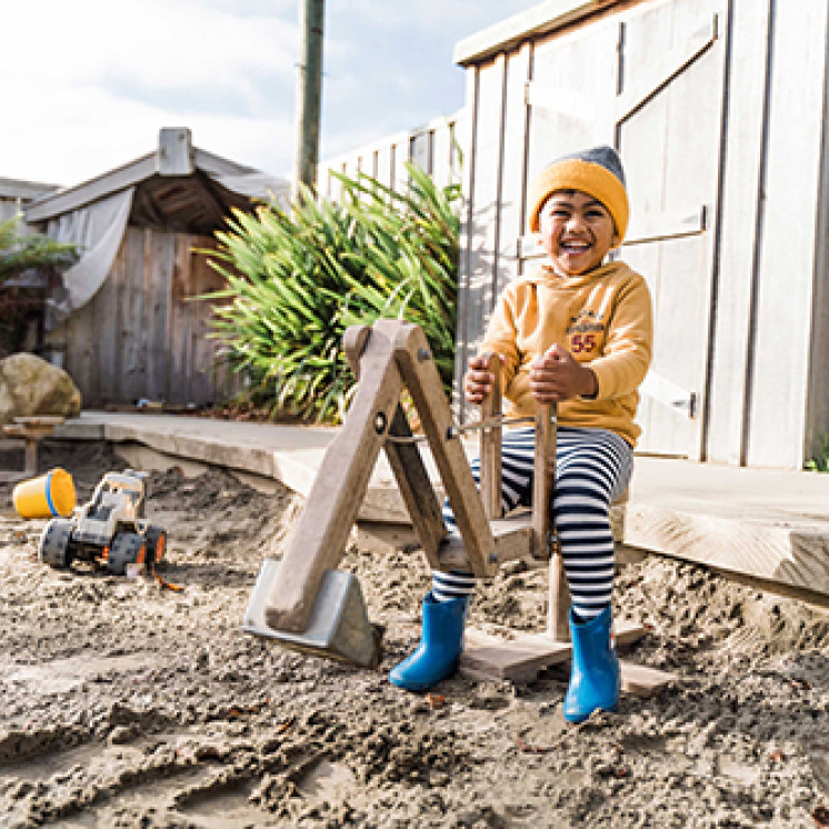 Child using a digger in sandpit at Busy Bees Terrace End