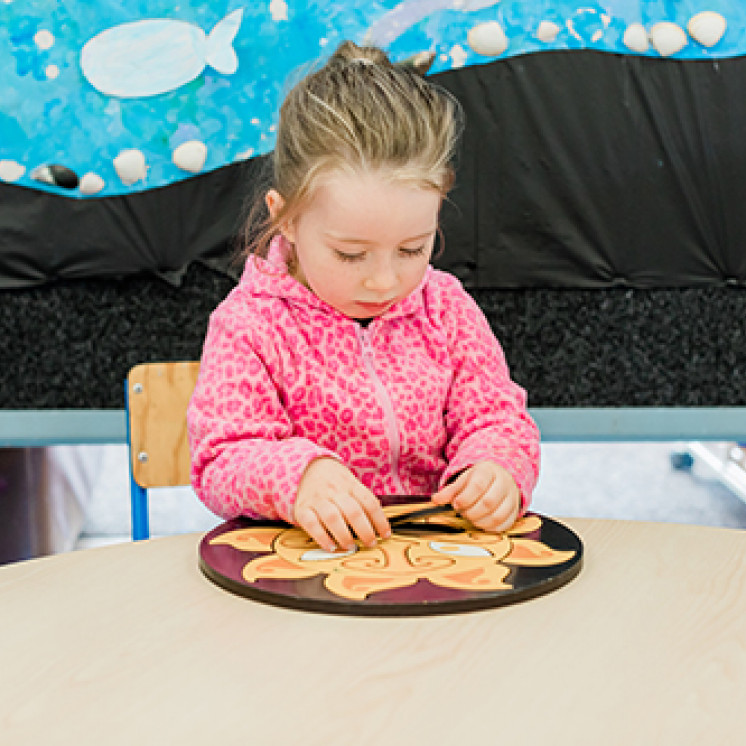 Little girl doing puzzles at Busy Bees Waitara