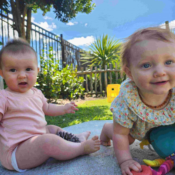 Two little girls playing in the sunshine at Busy Bees Tairāwhiti childcare in Gisborne