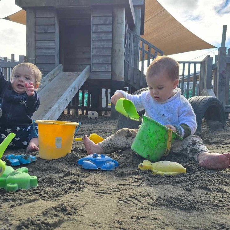 babies playing in sand box with diggers at Busy Bees Tairāwhiti childcare in Gisborne