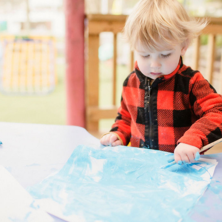 Toddler painting at Silverstream Early Learning by Busy bees